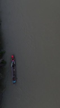 Ormandaki nehirde yüzen küçük balıkçı teknelerinin dikey İHA görüntüleri