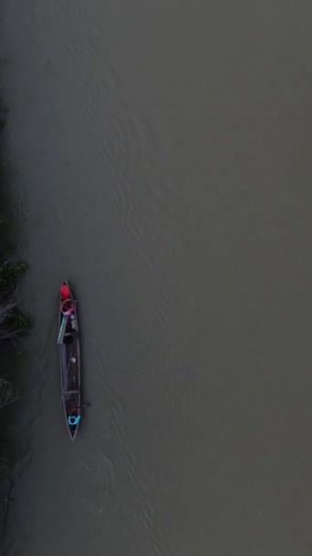 森の川に浮かぶ小さな漁船の垂直ドローン映像 — ストック動画