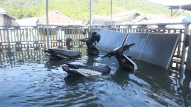 Motorbike submerged in floodwater in Tualango village, Gorontalo clipart