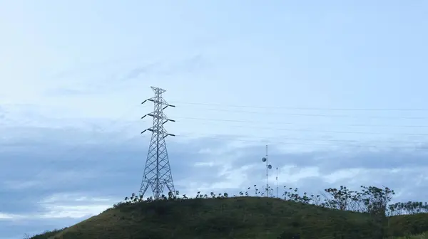 stock image High voltage power line in the blue sky with cloud and green hill