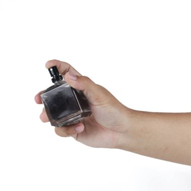 Adamın eli, beyaz arka planda izole edilmiş bir parfüm şişesini tutuyor.