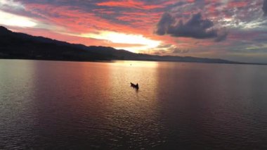 Gün batımında göl kenarındaki bir teknenin güzel gökyüzü manzarası.