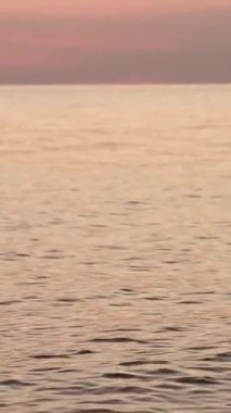 Denizde gün batımı dalgalar ve sudaki yansımalarla