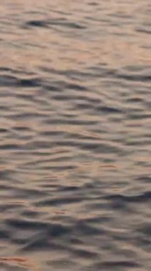 Denizde gün batımı dalgalar ve sudaki yansımalarla