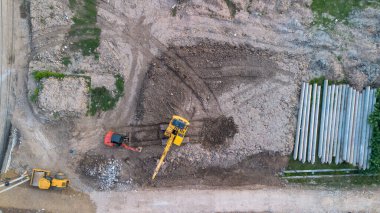 İnşaat alanında çalışan kazıcının hava görüntüsü, üst görünüm