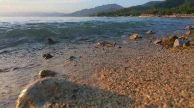 Sunset 'te Sandy Sahili' nde Dalgaların Yakın Çekimi. Yavaş çekim