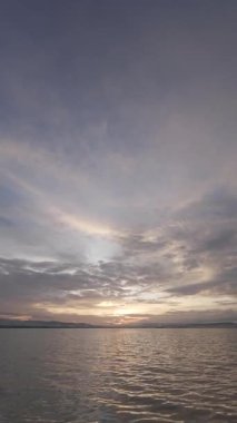 Yavaş çekim Bulutlu Suyun Üzerinde Gün Batımı