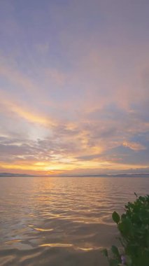 Yavaş çekim Bulutlu Suyun Üzerinde Gün Batımı