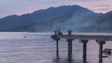 Rıhtımda Dağlara ve Denize Bakan İnsanlar