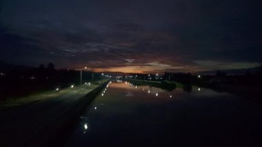 Dusk 'ta sokak ışıklarıyla nehir manzarası