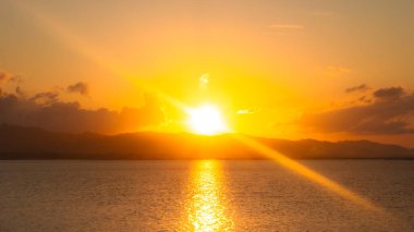 Su ve Uzak Dağların Üzerinde Altın Gün Batımı