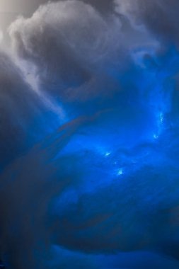 Renkli ışık, pamuklu kar ve yapay kar kullanılarak yapılan soyut bir resim. Gökyüzündeki bulutların dramatik konsepti, denizde fırtına, aydınlık ve karanlık, atmosferik durumlar. Arkaplan ya da duvar kağıdı.