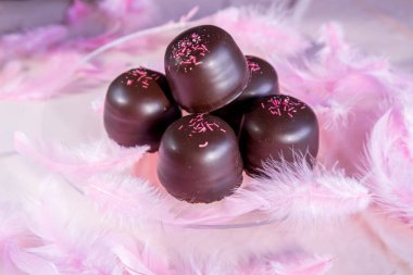 Altında çikolata ve vanilyalı gofretle kaplı pembe arka planda sünger şekeri..