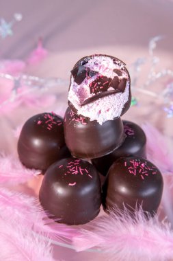 Altında çikolata ve vanilyalı gofretle kaplı pembe arka planda sünger şekeri..