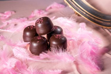 Altında çikolata ve vanilyalı gofretle kaplı pembe arka planda sünger şekeri..