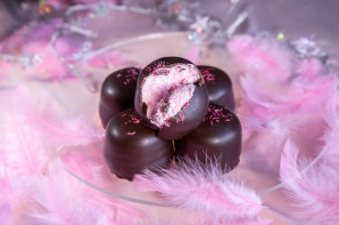 Altında çikolata ve vanilyalı gofretle kaplı pembe arka planda sünger şekeri..