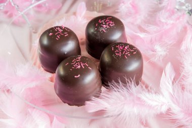 Altında çikolata ve vanilyalı gofretle kaplı pembe arka planda sünger şekeri..