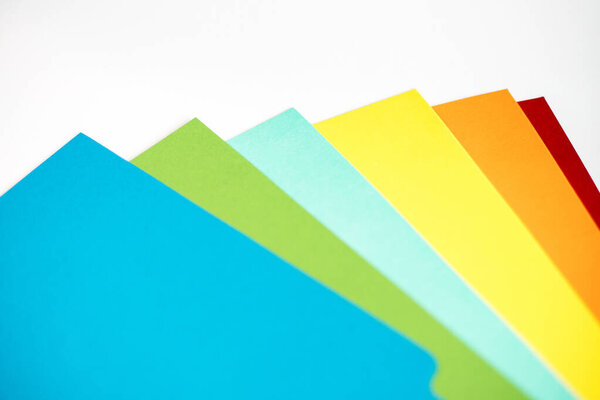 Colored sheets of paper superimposed on each other on white background.