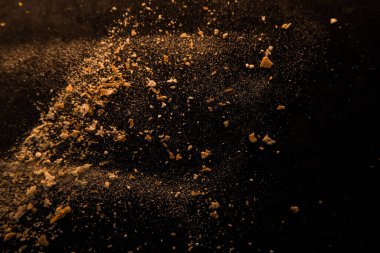 Un ve ekmek kırıntılarından oluşan koyu arkaplanda soyut bir resim. Kavramsal görüntü, uzaya ve evrene atıfta bulunma, bilinmeyen, ışık ve karanlık..