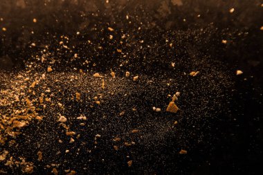 Un ve ekmek kırıntılarından oluşan koyu arkaplanda soyut bir resim. Kavramsal görüntü, uzaya ve evrene atıfta bulunma, bilinmeyen, ışık ve karanlık..