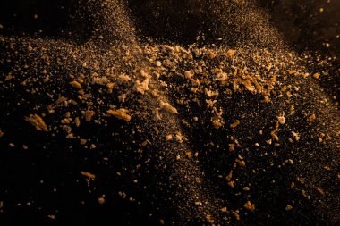 Un ve ekmek kırıntılarından oluşan koyu arkaplanda soyut bir resim. Kavramsal görüntü, uzaya ve evrene atıfta bulunma, bilinmeyen, ışık ve karanlık..