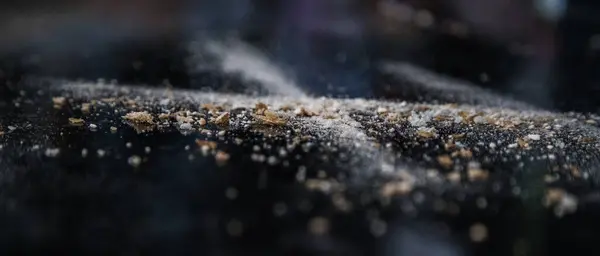 Un ve ekmek kırıntılarından oluşan koyu arkaplanda soyut bir resim. Kavramsal görüntü, uzaya ve evrene atıfta bulunma, bilinmeyen, ışık ve karanlık..