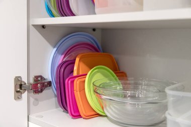 Mutfak dolabı plastik ve cam kaplarla dolu..