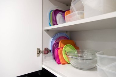 Mutfak dolabı plastik ve cam kaplarla dolu..