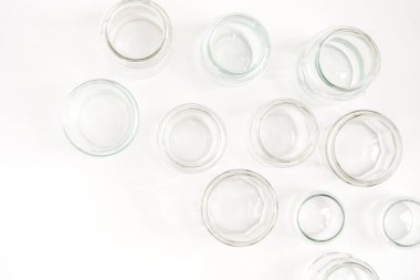 Beyaz arka planda kapağı olmayan çeşitli cam kaplar, geri dönüşüm. Malzemelerin ikinci yaşam kavramı, cam şişelerin çeşitli kullanımları.