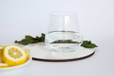 İçinde limonlu maden suyu ve beyaz arka planda naneli cam bardak. Limon ve nane bazlı ferahlatıcı içecek. Lezzetli ve sağlıklı limonata..
