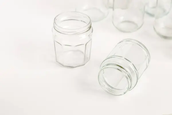 Assorted set of glass containers without lids on white background, recycling. Concept of second life to materials, various uses for glass vials.