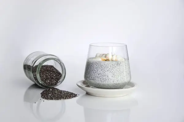Salvia Hispanica bitkisinden Chia tohumları. Çeşitli tariflerde kullanmak için çok sağlıklı işlevsel yiyecekler. İçinde doğal yoğurtla sulandırılmış tohumlar olan cam bardak..