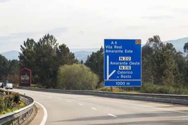 A4 otoyolunun, transmontana otoyolunun, Porto 'nun, Vila Real' in, Portekiz 'in görüntüleri. Mavi dikey bilgi panosu, yönler. Bulutlarla dolu güzel bir gün.