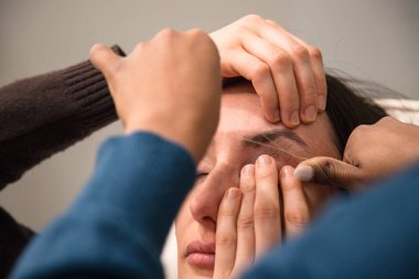 Beyaz kadın kaş stilistinin kullandığı iplik tekniğiyle kaşlarındaki kılları alıyor. İplik. İşlem Adımları. Kapat.