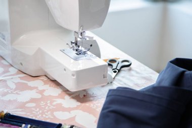 Dikiş makinesi ve bazı aksesuarlar, çalışma alanı ev veya atölye.