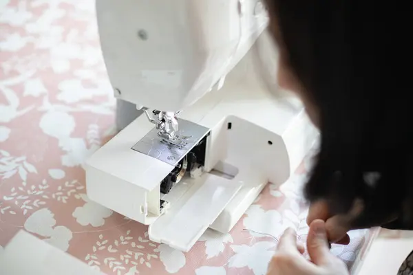 Dikiş makinesinin bileşenlerine yakından bak, iğnenin bir parçası ve baskılı ayak. Kullanmak için makinenin bakımını yapan kişi.