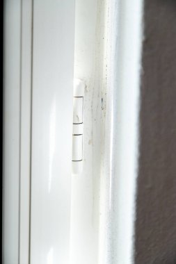 Beyaz iç menteşe PVC veya plastik malzeme. Kapı ya da pencerenin ayrıntıları. Malzemelerin korunumu ve temizliği kavramı, nem ve küf ve kir.