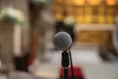 Ön plandaki mikrofon bir kilisede ya da dini mekanda kullanılmaya hazır. Bulanık kilise geçmişi.