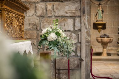 Tapınma yerindeki çiçek süslemeleri, kilise. Düğün için şenlik dekorasyonu. Çiçek düzenlemeleri ağırlıklı olarak beyaz ve yeşil.