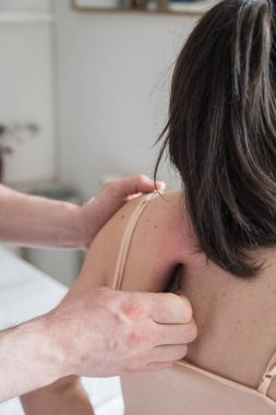 Beyaz Kadın Vücut Tedavisine Gidiyor. Deri kazıma tekniği üzerinde çalışan bir terapist. Çin tekniği, gua sha, ağrı kesici ve tedavi için ve kan dolaşımını aktive etmek için. Uyarıcı terapi.