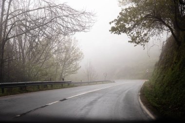 Ulusal karayolu 103, N103, Viana do Castelo ve Bragana belediyeleri arasında çok bulutlu ve sisli bir günde. Ağaçların silueti.