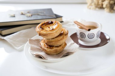 Pasteis de nata, Portekiz mutfağının geleneksel tatlısı. Küçük, çıtır çıtır börekler ve yumurtadan krema. Sık sık kahveyi tattı ve eşlik etti. Masayı beyaz arkaplanda ayarla.