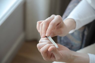 Evde tırnaklarını dikkatlice törpüleyen, özen ve bakım üzerine odaklanan biri. Kapat.