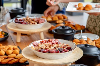 Açık büfe tarzı yemekleri seven insanlar, aperatifler ve aperatifler de dahil olmak üzere çeşitli yemeklerden servis ediyorlar, sosyal yemek için günlük ve davetkar bir ortam yaratıyorlar..