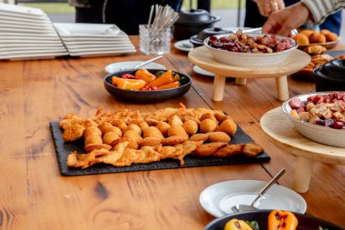 Açık büfe tarzı yemekleri seven insanlar, aperatifler ve aperatifler de dahil olmak üzere çeşitli yemeklerden servis ediyorlar, sosyal yemek için günlük ve davetkar bir ortam yaratıyorlar..