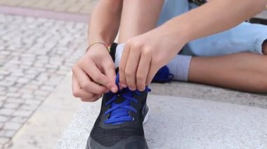 Ayakkabı bağcıklarını bağlamaya çalışan bir çocuğun ayrıntıları. Özerklik kavramı, yeni becerilerin edinilmesi.