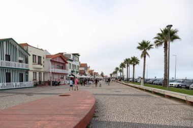 Costa Nova do Prado, Aveiro, Portekiz - 30 Ağustos 2024 Portekiz turizm sokağı sembolik çizgili ve renkli evleriyle. Günün sonunda..