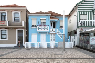 Costa Nova do Prado, Aveiro, Portekiz - 30 Ağustos 2024 Portekiz turizm sokağı sembolik çizgili ve renkli evleriyle. Günün sonunda..