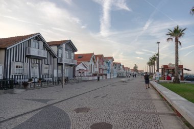 Costa Nova do Prado, Aveiro, Portekiz - 30 Ağustos 2024 Portekiz turizm sokağı sembolik çizgili ve renkli evleriyle. Günün sonunda..