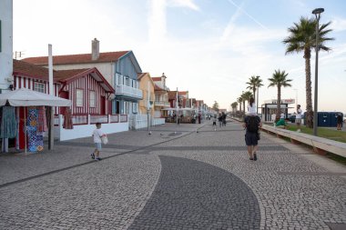 Costa Nova do Prado, Aveiro, Portekiz - 30 Ağustos 2024 Portekiz turizm sokağı sembolik çizgili ve renkli evleriyle. Günün sonunda..
